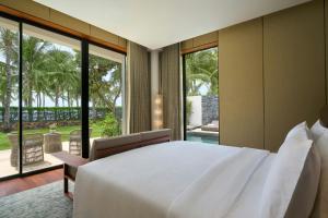 une chambre avec un grand lit blanc et de grandes fenêtres dans l'établissement JW Marriott Cam Ranh Bay Resort & Spa, à Cam Ranh 54 autres photos