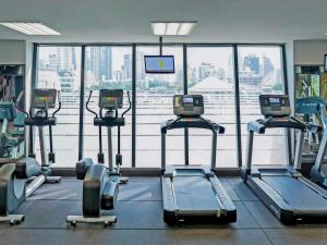 a gym with several tread machines in front of a large window at Grand Mercure Bangkok Atrium in Bangkok +53 photos