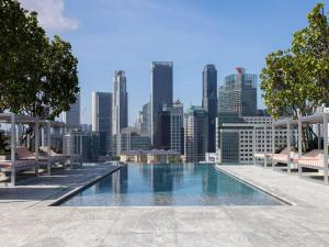 シンガポールにあるMondrian Singapore Duxtonの市街のスカイラインを背景にしたスイミングプール