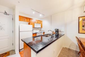 a kitchen with a sink and a white refrigerator at Town Plaza, Unit 209 in Whistler