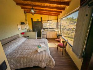 a bedroom with two beds and a large window at Cuesta de las Piedras in La Cumbrecita