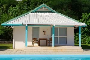 a small cottage with a table and chairs next to a pool at Hotel Albatros Wallis 