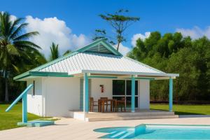 a small cottage with a table and chairs next to a pool at Hotel Albatros Wallis in Alele