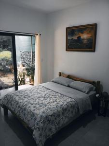 a bedroom with a bed and a large window at Morada Gaia in Tempate