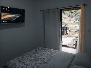 a bedroom with a bed and a tv and a window at Morada Gaia in Tempate +26 photos