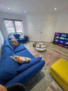 een woonkamer met een blauwe bank en een tv bij Sleaford Luxury Country Stay in Sleaford