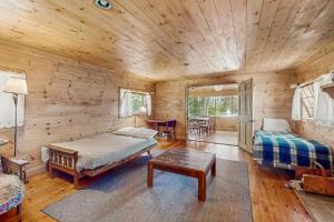 Un dormitorio tipo cabaña de madera con una cama y una mesa. en Garden Island's Pine, en Charlotte