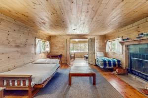 a bedroom in a log cabin with a bed and a fireplace at Garden Island's Pine in Charlotte