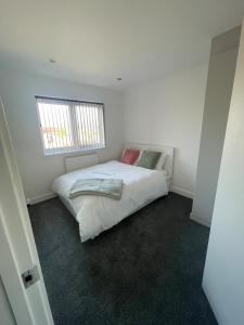 een slaapkamer met een bed in een witte kamer bij Sleaford Luxury Country Stay in Sleaford