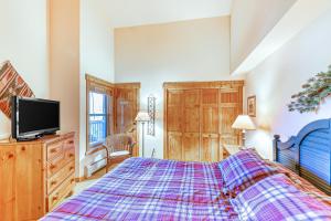 ein Schlafzimmer mit großem Bett und Fernseher in der Unterkunft Tenderfoot Lodge 2664 in Snake River Health Services Incorporated Heliport + 12 Fotos