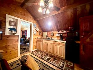 a kitchen with a refrigerator and a sink in a cabin at Big Bear Log cabin in Cosby