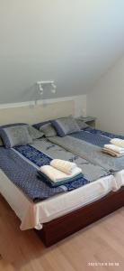twee bedden in een kamer met handdoeken erop bij Magyar Tenger Pihenőház, 4-8 főre Balatonakarattya in Balatonakarattya +38 foto's