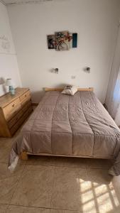 a bedroom with a large bed and a wooden dresser at alaguthe in Olavarría