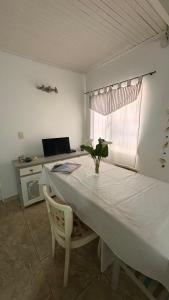 a white table with a vase on it in a room at alaguthe in Olavarría
