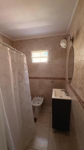 a bathroom with a sink and a toilet and a mirror at alaguthe in Olavarría