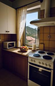 une cuisine avec une cuisinière et un bol de fruits sur le comptoir dans l'établissement ElaPhos HOUSE, à Kiriákion
