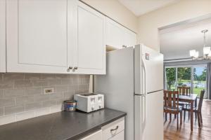 a kitchen with white cabinets and a white refrigerator at Lodge Condo 26 in Stowe