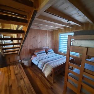 um quarto com uma cama e um beliche em Domos Conguillío - Cabaña en el bosque em Melipeuco
