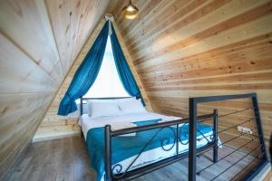 a bedroom with a bed in a wooden cabin at Cottage Liantto in Borjomi