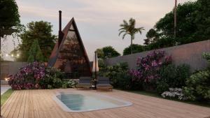 a garden with a pool and a chair and flowers at Cabanas Farol in Pântano Grande +9 photos