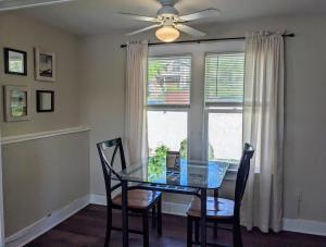 a dining room with a glass table and chairs and a window at Casual Living Extended Stay Hotels in Algonquin