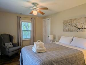 a bedroom with a bed with a ceiling fan and a chair at Casual Living Extended Stay Hotels in Algonquin