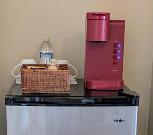 a red blender and a basket on top of a refrigerator at Casual Living Extended Stay Hotels in Algonquin