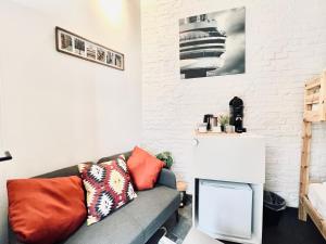 a living room with a couch and a white brick wall at Casa Terraza in Hasselt