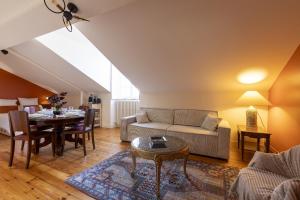 a living room with a couch and a table at Les appartements de l'Orangerie in Jarnac