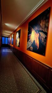 a hallway with pictures on the walls of a building at Les appartements de l'Orangerie in Jarnac