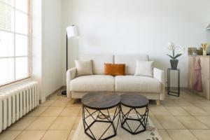 a living room with a couch and a table at Les appartements de l'Orangerie in Jarnac