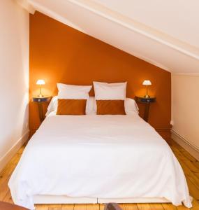a bedroom with a large white bed with two lamps at Les appartements de l'Orangerie in Jarnac +80 photos