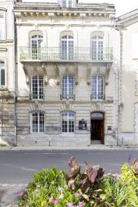 an old building with a balcony on the side of it at Les appartements de l'Orangerie in Jarnac +5 photos