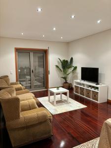 EstelaにあるCasa Gomesのリビングルーム(椅子、薄型テレビ付)