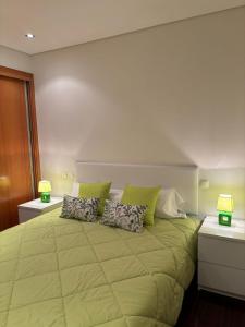 EstelaにあるCasa Gomesの緑の枕が付いた大きなベッドのある寝室