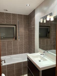 EstelaにあるCasa Gomesの浴槽、洗面台、鏡のあるバスルーム +14枚の写真