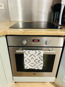 a stove top oven with a towel on it at Le Petit Bourcain in Bourg-lès-Valence
