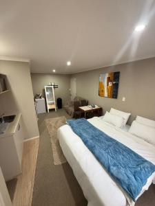 a bedroom with a large bed and a living room at Casa Miguelle a Private 1br mini house in Dunedin