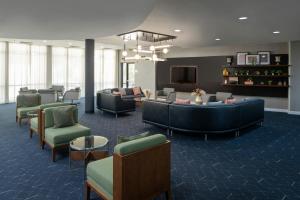 a lobby with couches and chairs and a tv at Courtyard Texarkana in Texarkana - Texas