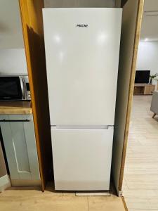 a white refrigerator in a kitchen next to a microwave at Le Petit Bourcain in Bourg-lès-Valence +18 photos