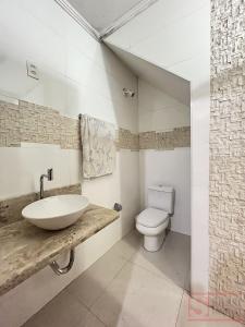 a bathroom with a sink and a toilet at Pousada Miriam in Limeira