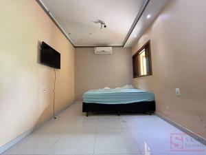 a room with a bed and a television in it at Pousada Miriam in Limeira