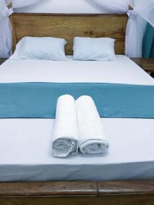 a bed with two towels and two pillows on it at Changamwe accomodations in Mombasa