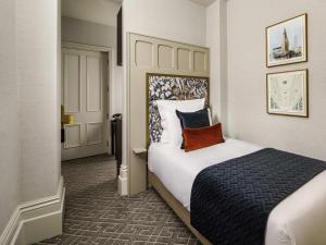 a hotel room with a large bed and a door at The Municipal Hotel Liverpool - MGallery in Liverpool