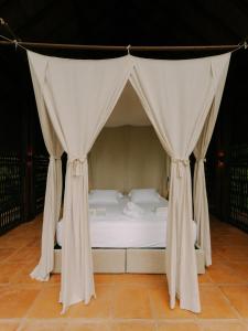 a bed in a tent with curtains around it at Sandagua hotel in Puerto Triunfo +13 photos