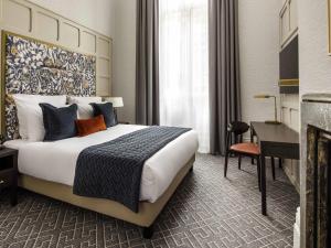 a hotel room with a large bed and a desk at The Municipal Hotel Liverpool - MGallery in Liverpool