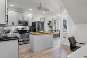a kitchen with white cabinets and stainless steel appliances at Iris Manor Luxury Modern Stay Near UAB in Birmingham