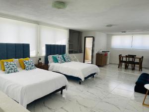 a hotel room with two beds and a table at Hotel Bungalows Casa Blanca in Tenancingo de Degollado +102 photos