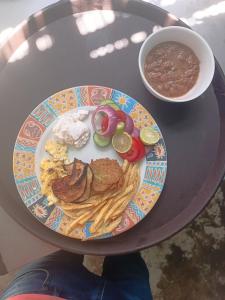 a table with a plate of food and a bowl of chili at مخيم مبروكه in Nuweiba‘ el Muzeinah