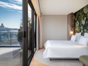 a bedroom with a white bed and a balcony at Swissôtel Tbilisi in Tbilisi City